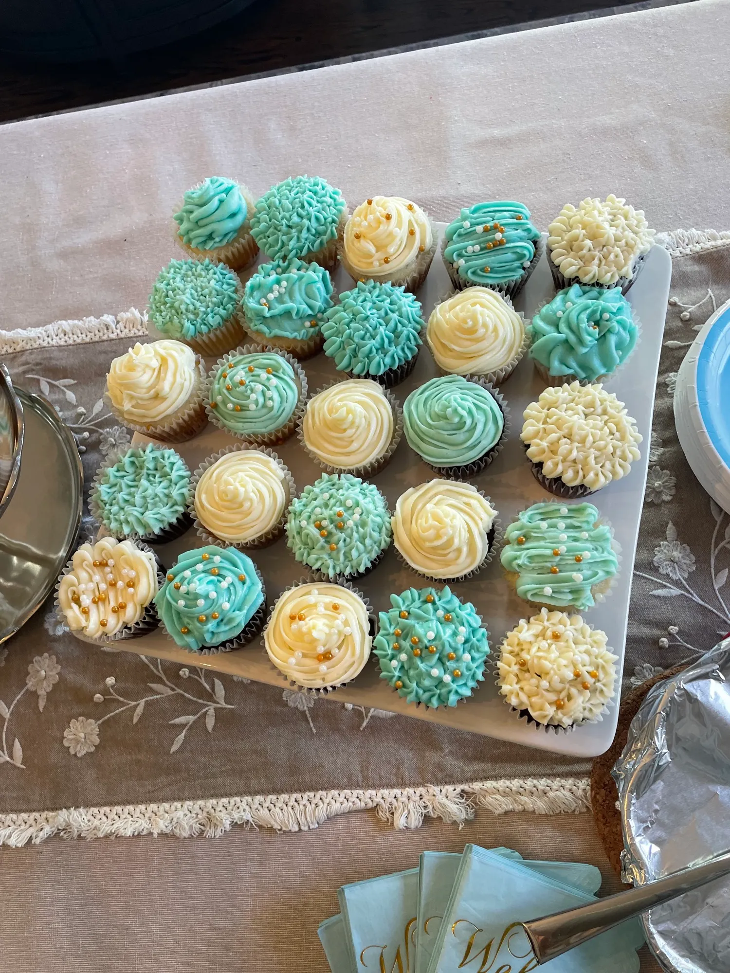 Blue and white cupcakes on a tiered display