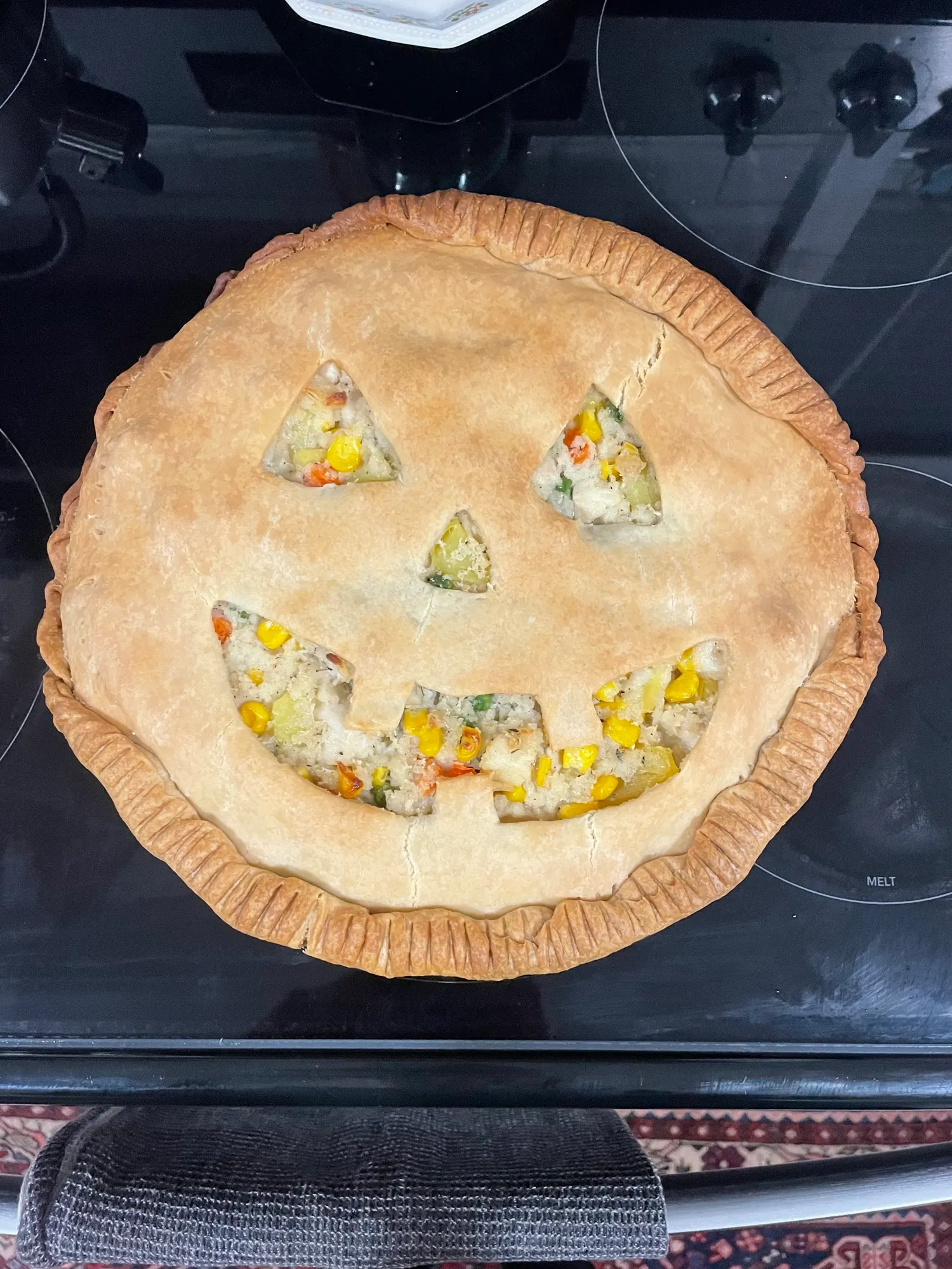 Halloween jack-o-lantern face cut into a pot pie