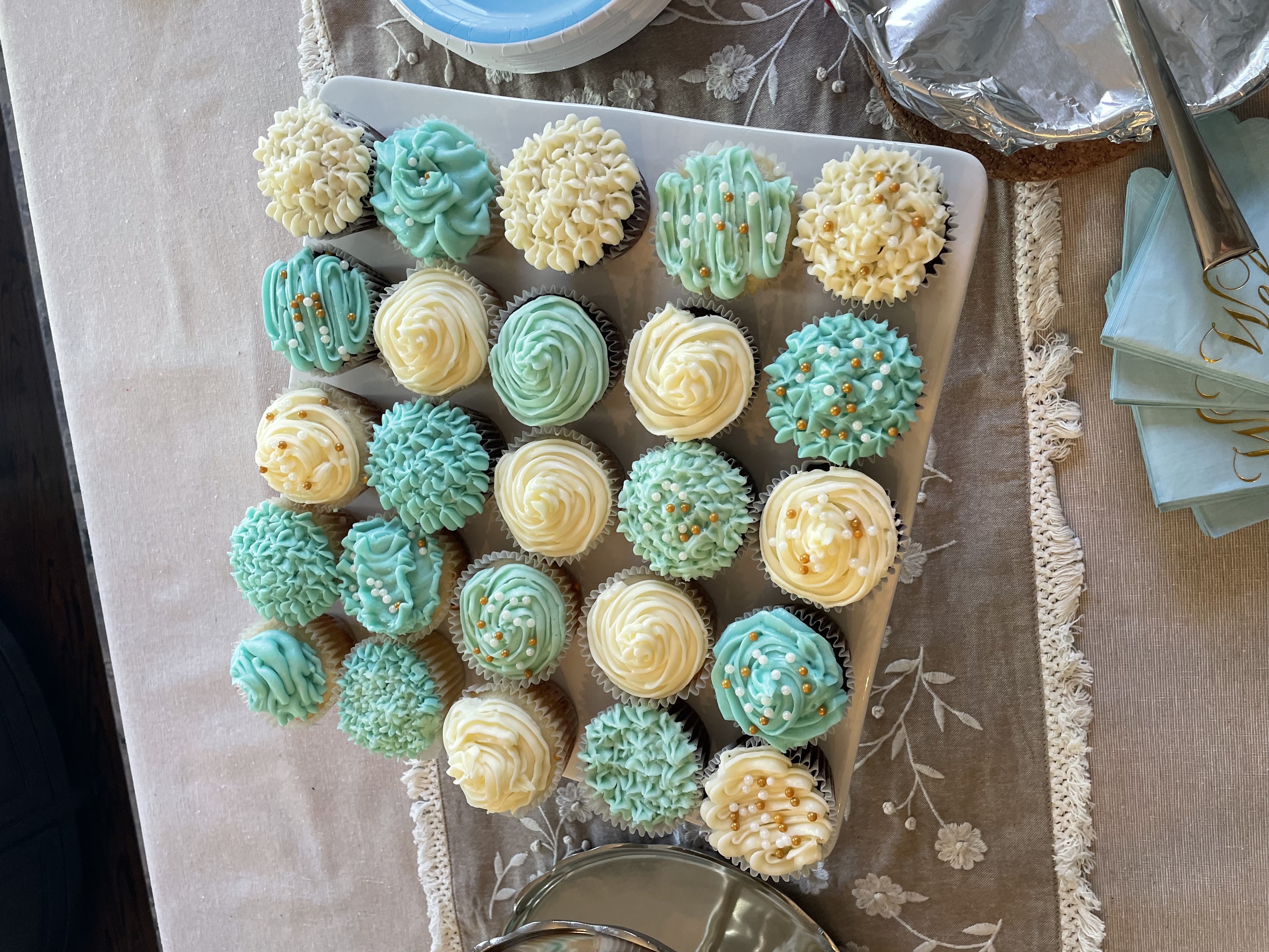 Blue and white cupcakes on a tiered display