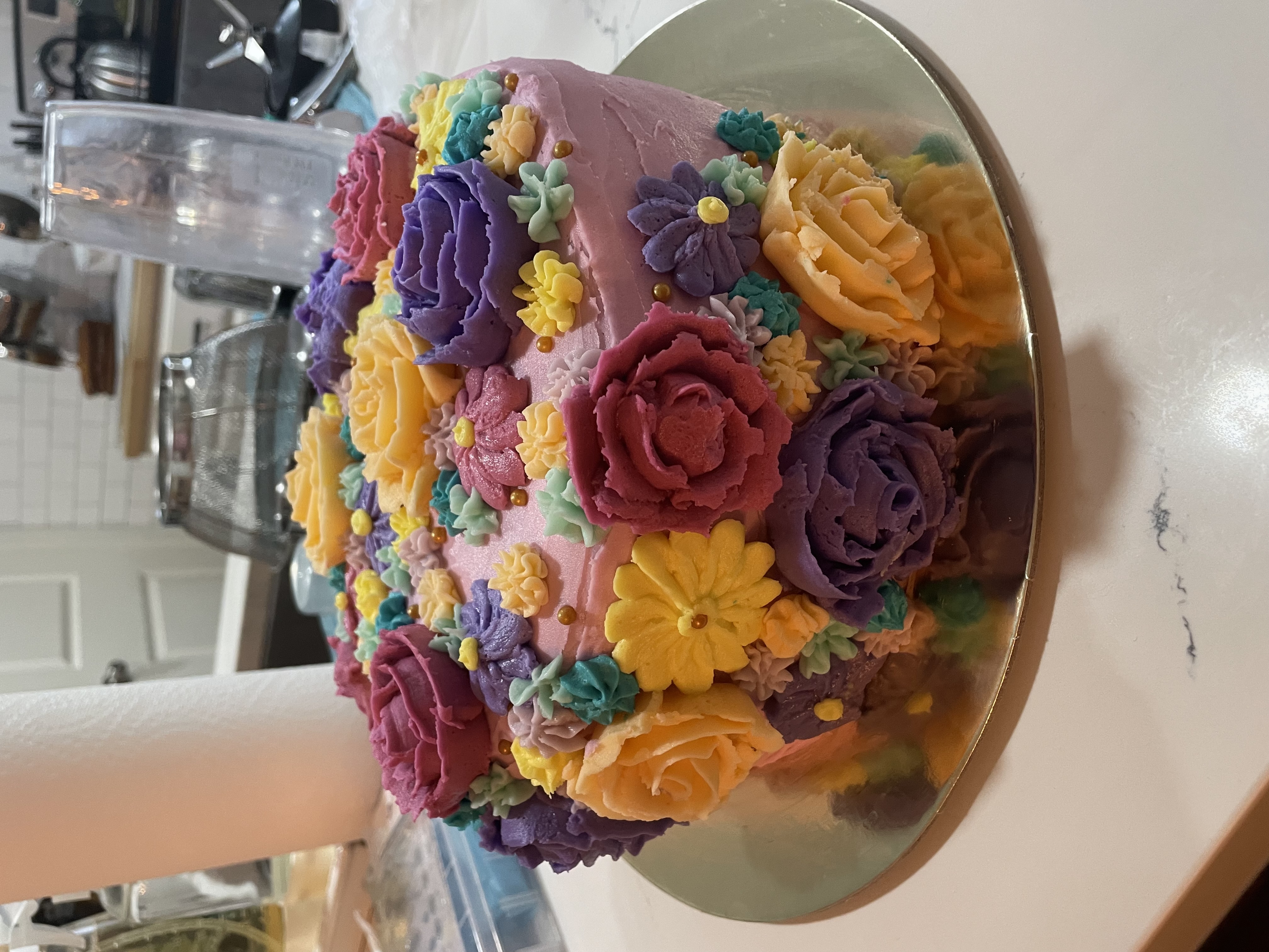Colorful birthday cake covered in buttercream flowers
