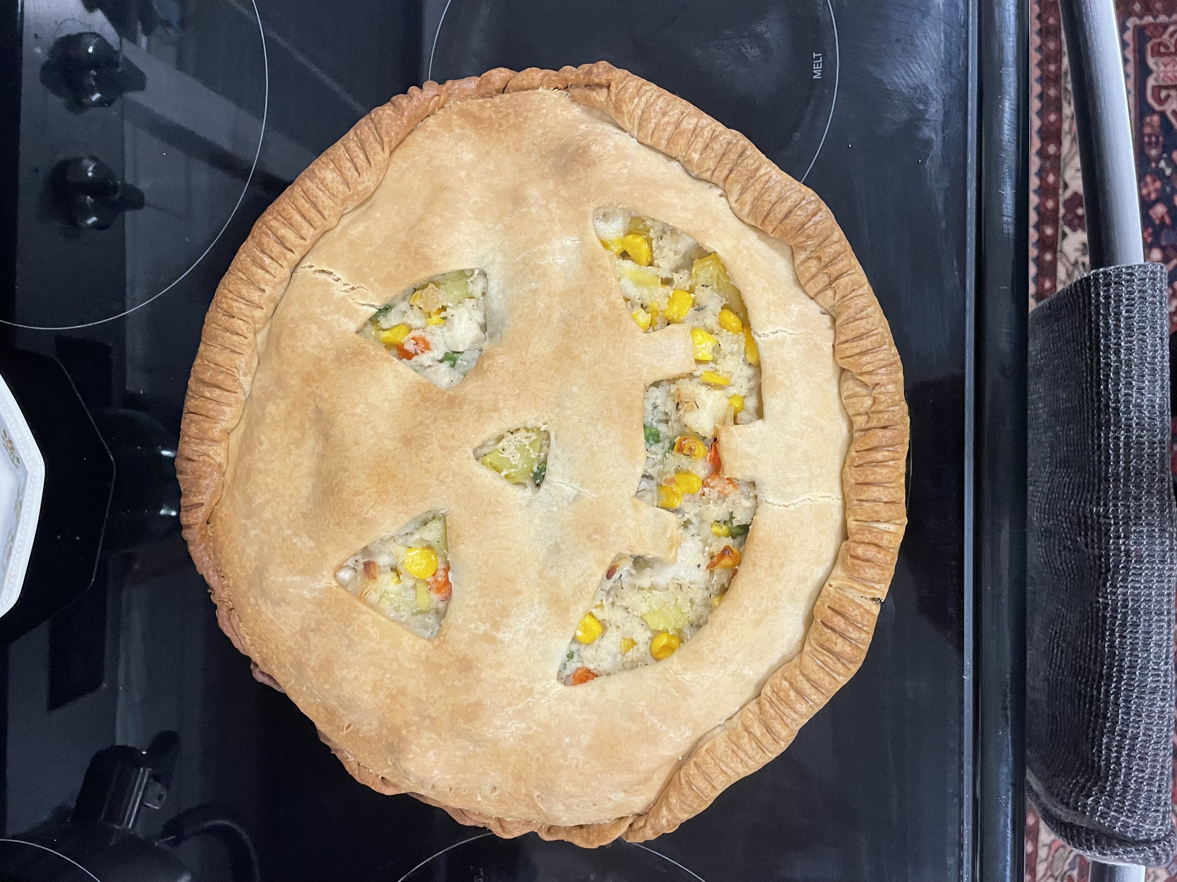 Halloween jack-o-lantern face cut into a pot pie