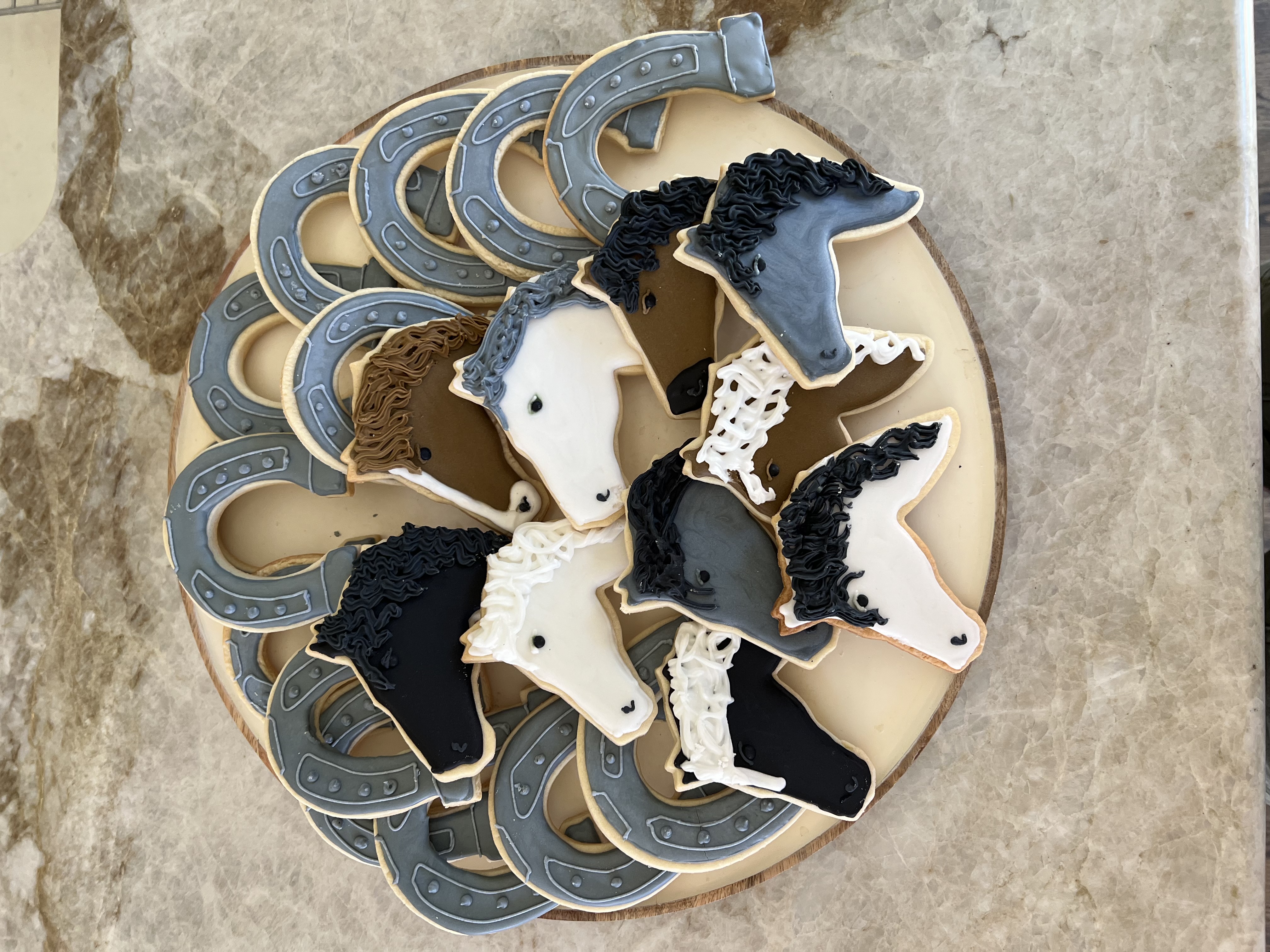 Custom decorated horse sugar cookies on a round board