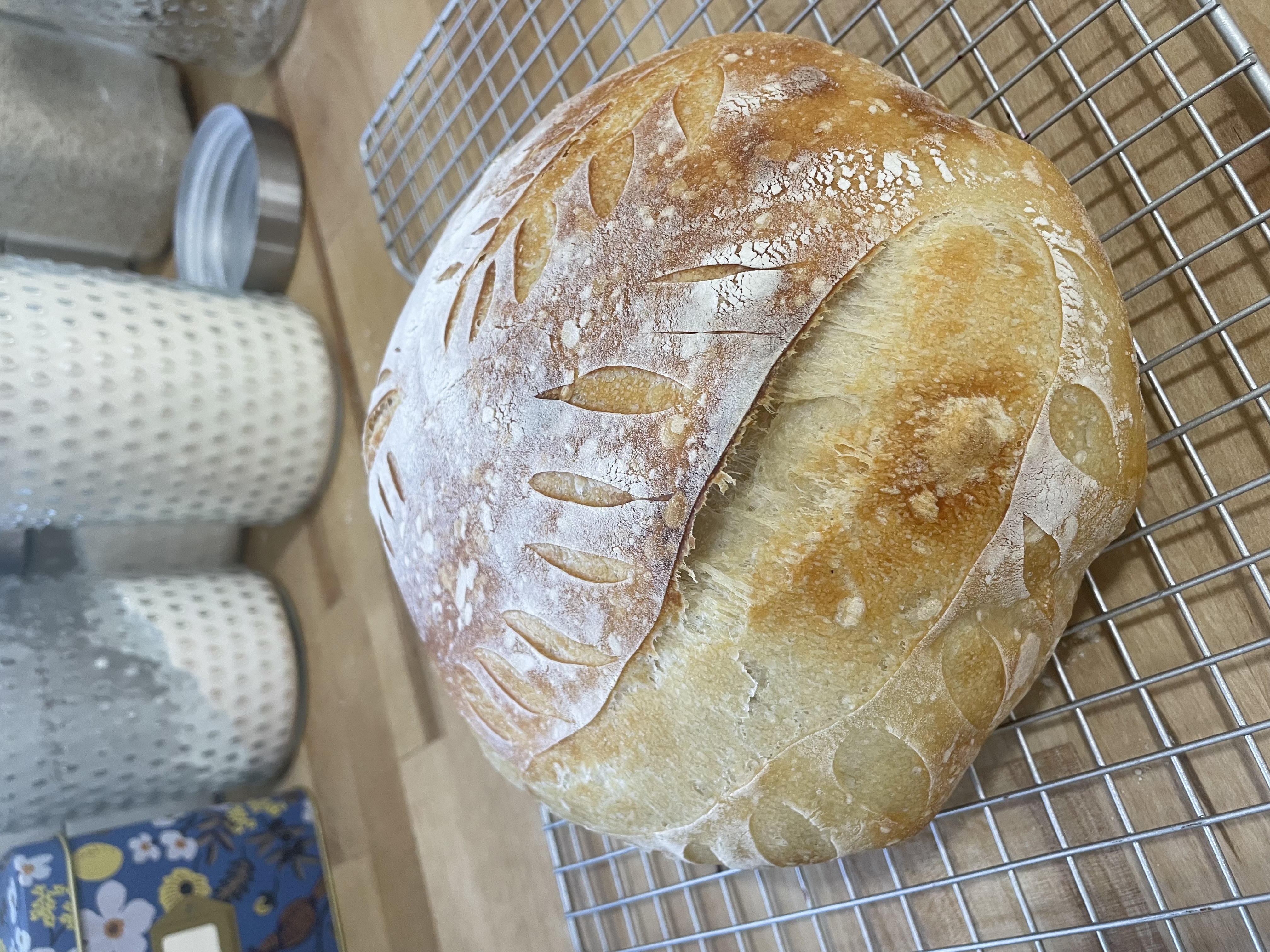 Scored sourdough loaf cooling on a wire rack
